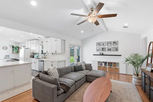 a living room with furniture kitchen view and a potted plant