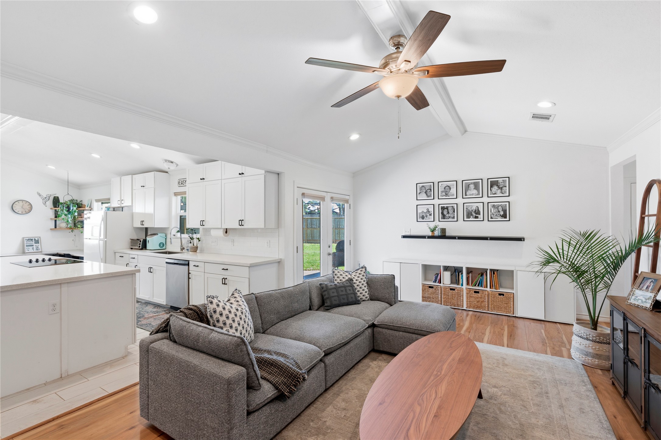 a living room with furniture kitchen view and a potted plant