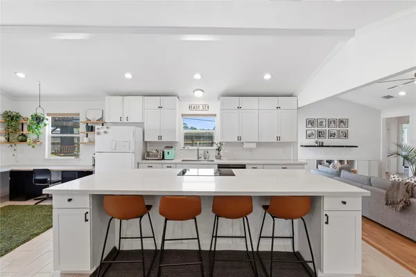 a kitchen with stainless steel appliances granite countertop a table chairs sink and cabinets
