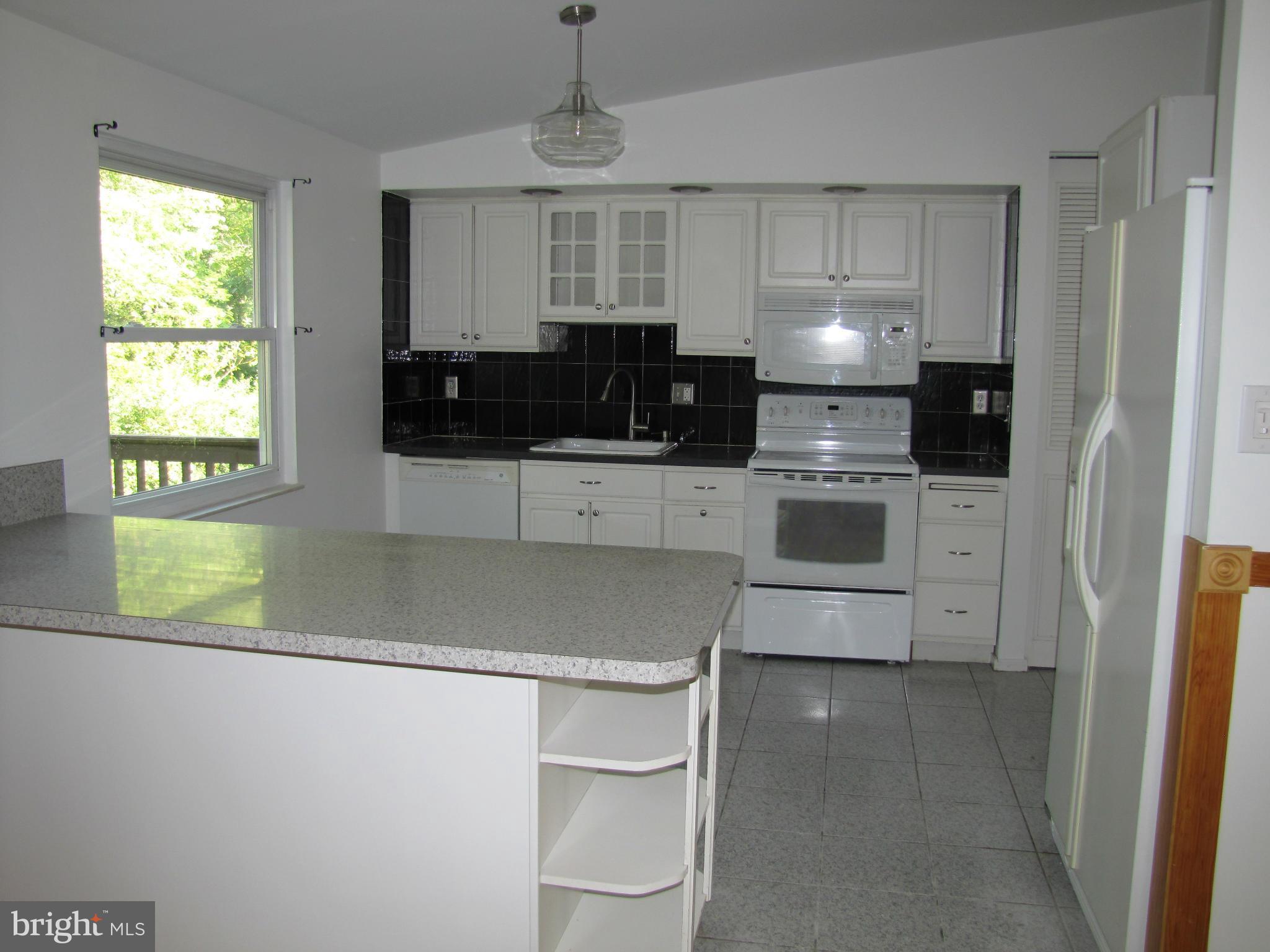 6348 Sandchain Road Columbia, MD 21045 - Photo 5 of 24 a kitchen with stainless steel appliances granite countertop a stove a sink and a microwave
