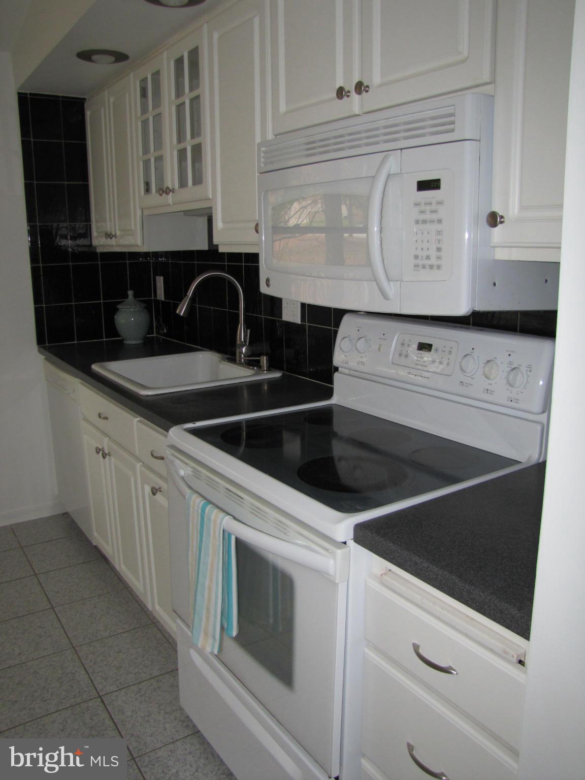 6348 Sandchain Road Columbia, MD 21045 - Photo 7 of 24 a kitchen with white cabinets and sink
