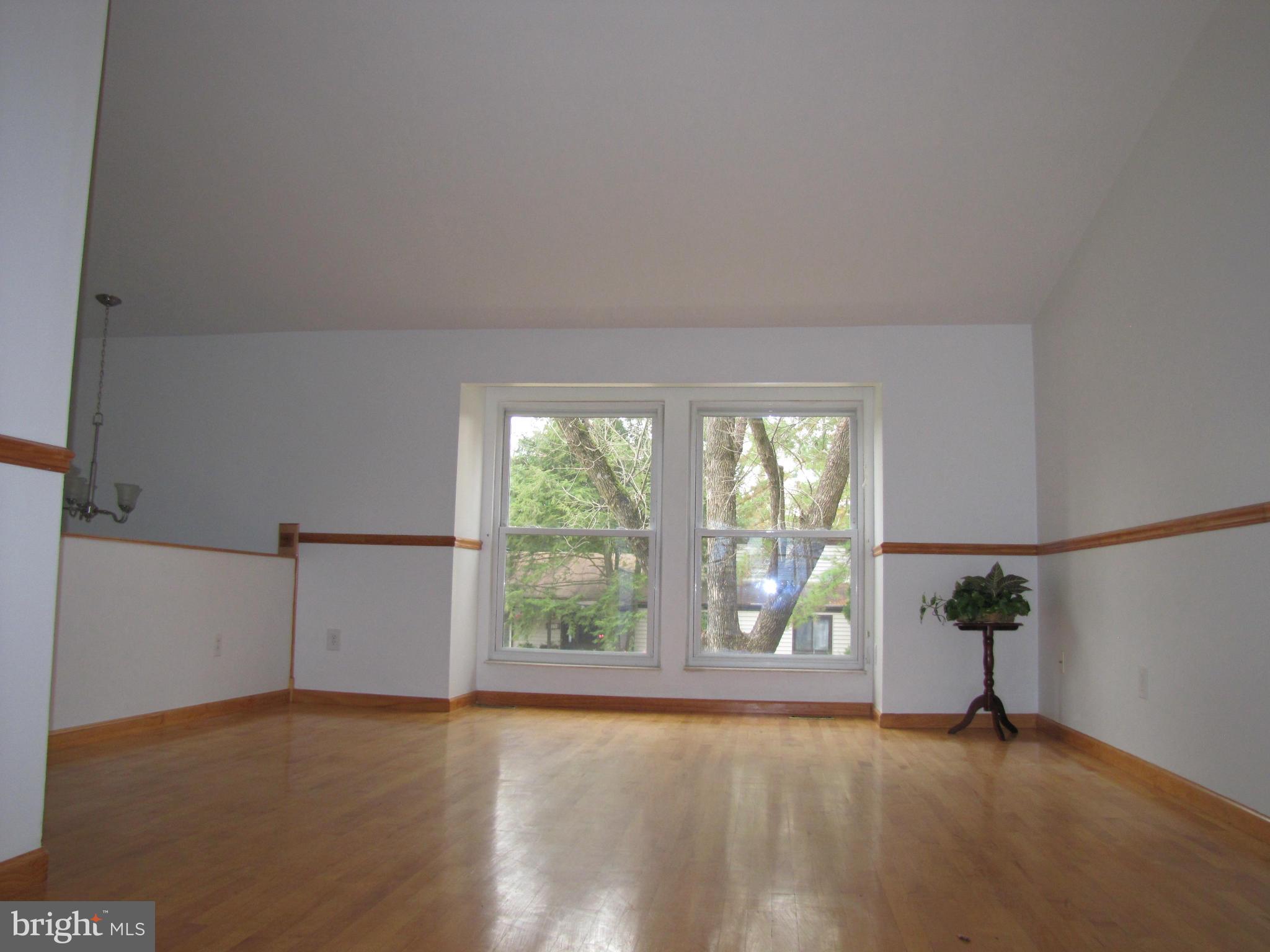 6348 Sandchain Road Columbia, MD 21045 - Photo 10 of 24 a view of an empty room with wooden floor and a window