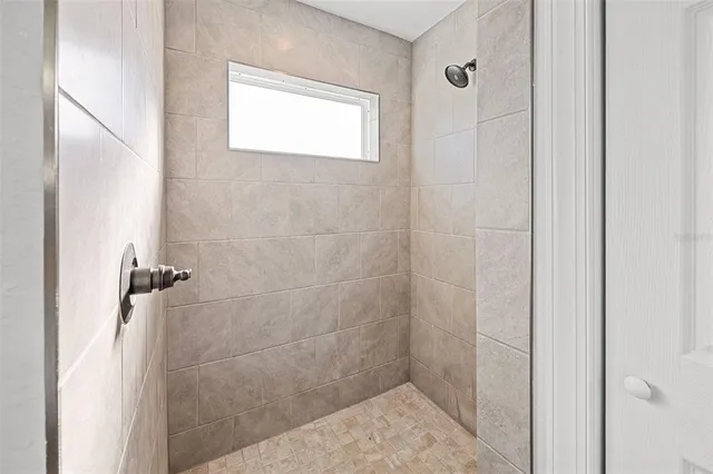 a spacious bathroom with a granite countertop sink a mirror and a shower