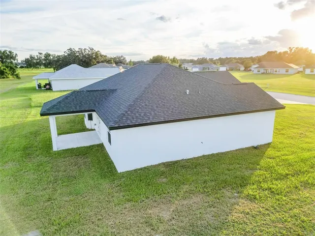 an aerial view of residential houses with outdoor space and ocean view