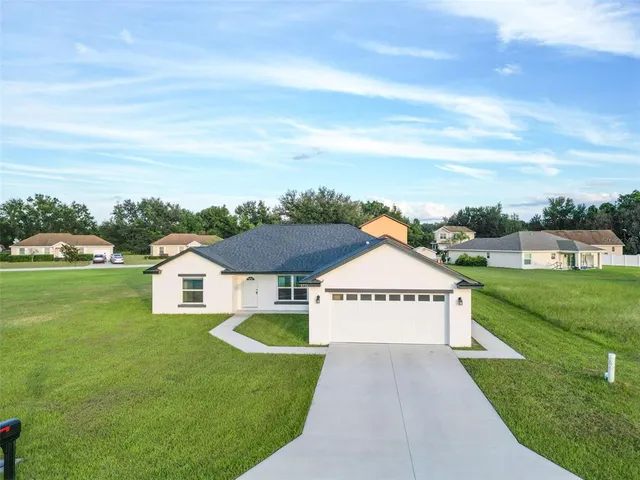 a view of a house with a yard and garage