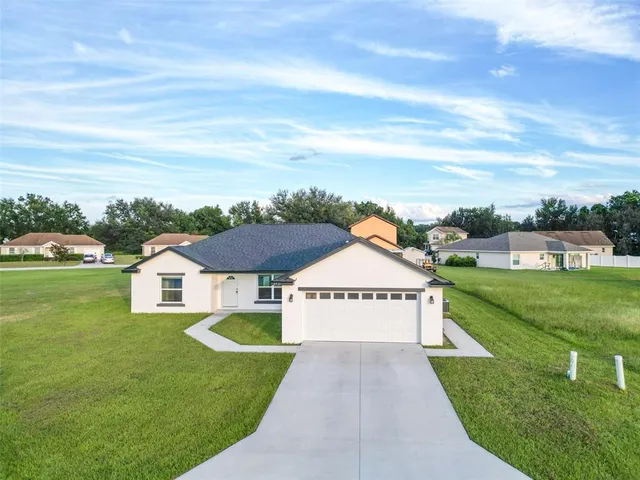 a aerial view of a house next to a big yard and large trees
