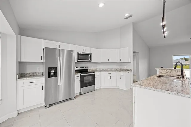 a kitchen with white cabinets and stainless steel appliances