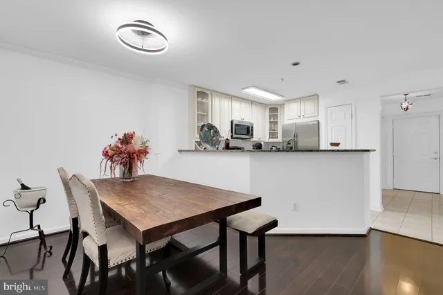 a kitchen with stainless steel appliances granite countertop a dining table chairs and granite counter tops