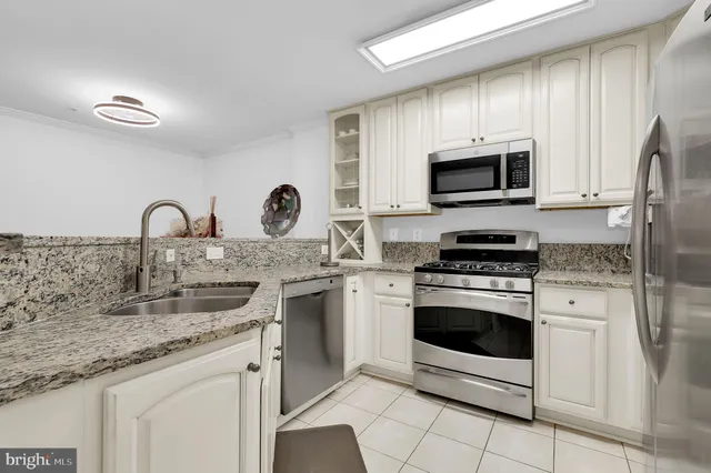 a kitchen with stainless steel appliances granite countertop a stove microwave and sink