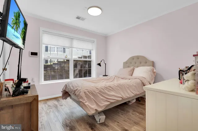 a bedroom with a bed and a flat tv screen on dresser