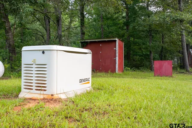 a backyard of a house with wooden fence and large trees