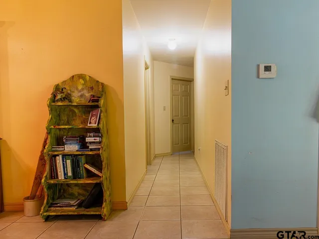 a view of a hallway with wooden floor and closet