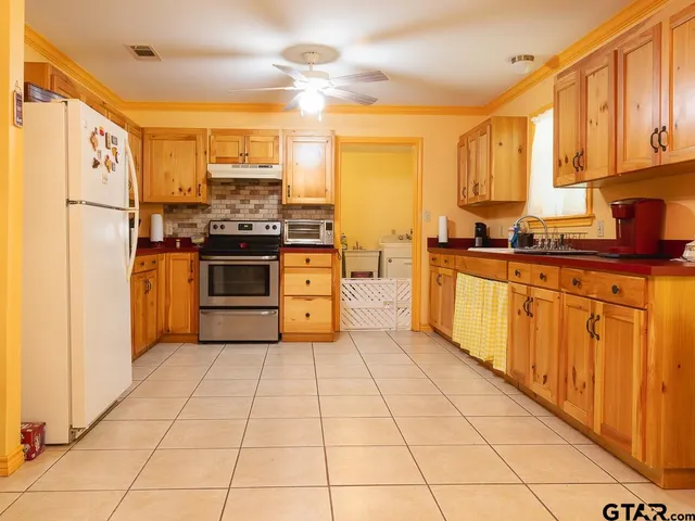 a kitchen with stainless steel appliances granite countertop a stove refrigerator sink and cabinets