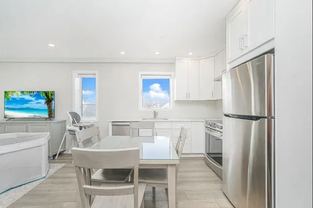 a kitchen with a table chairs refrigerator and microwave