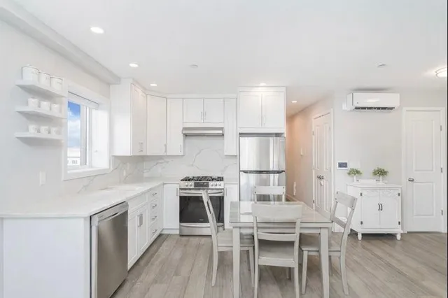 a kitchen with white cabinets and stainless steel appliances