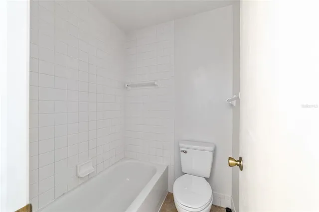 a white toilet sitting next to a bath tub