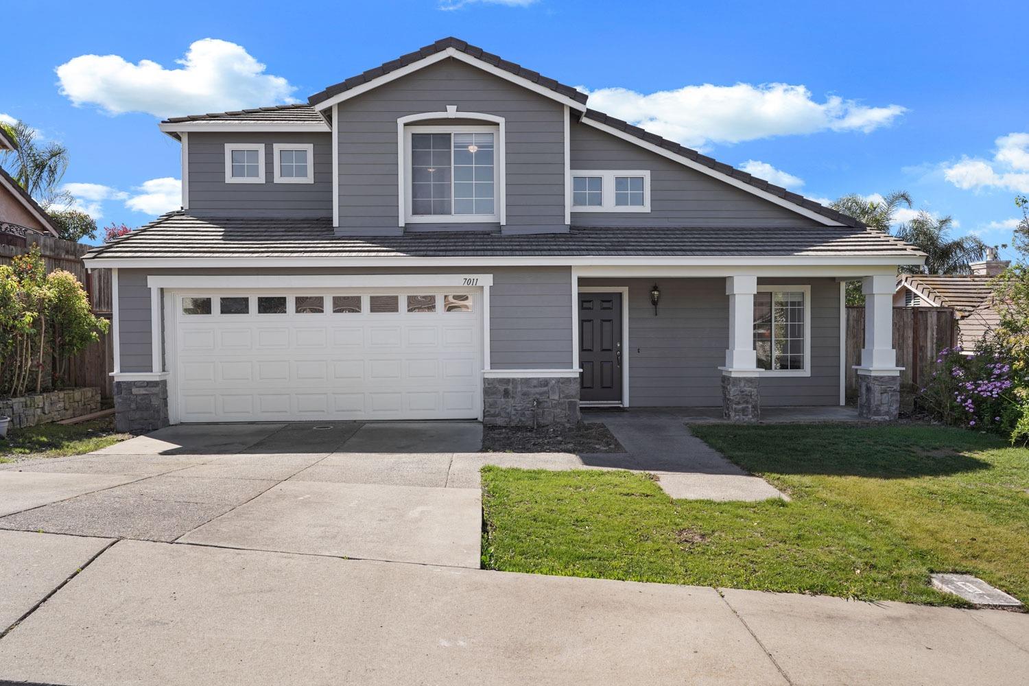 7011 Prestwick Drive Riverbank, CA 95367 - Photo 1 of 1 a front view of a house with a yard and garage