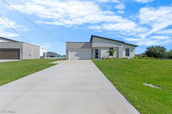 a view of a house with a yard and garage