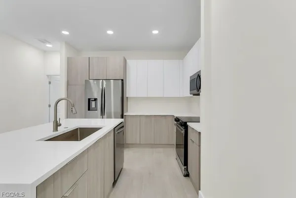 a kitchen with kitchen island a sink appliances and cabinets