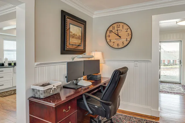 a view of a workspace with furniture and a window