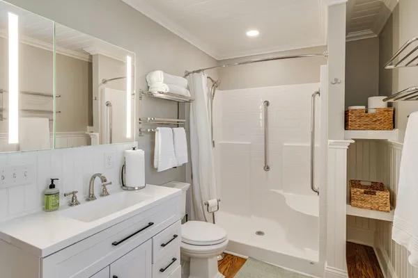 a bathroom with a sink a toilet and shower