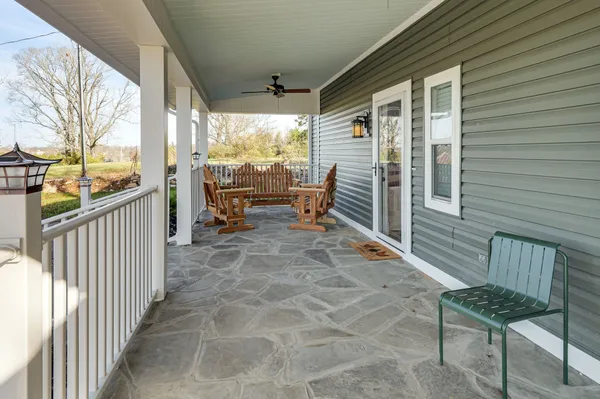 a balcony with chairs and wooden fence