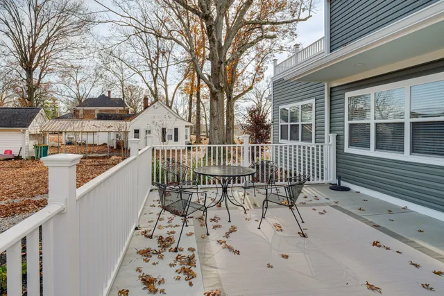 a view of a house with wooden deck and a trees
