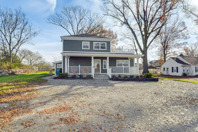 a view of a house with a yard and large tree