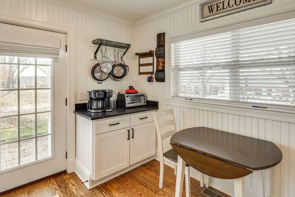 a kitchen with a table chairs and a window