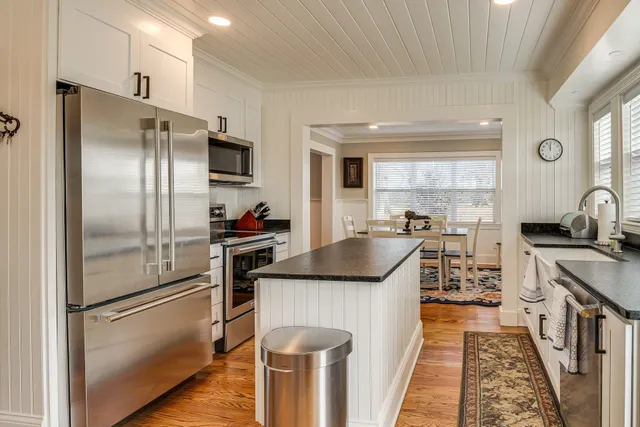 a kitchen with granite countertop a refrigerator stove and sink