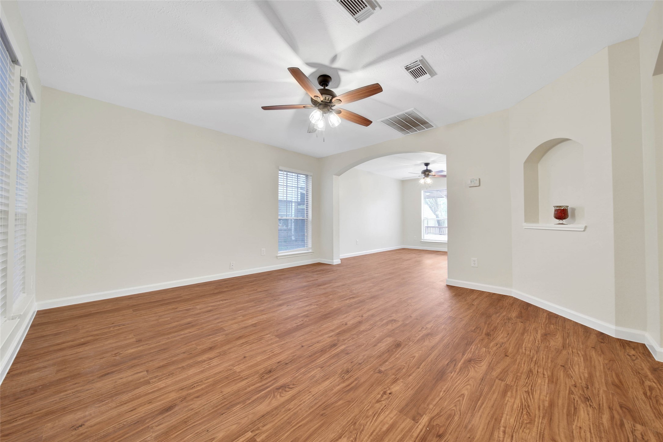 1427 Redwood Village Circle Spring, TX 77386 - Photo 15 of 43 an empty room with wooden floor ceiling fan and windows