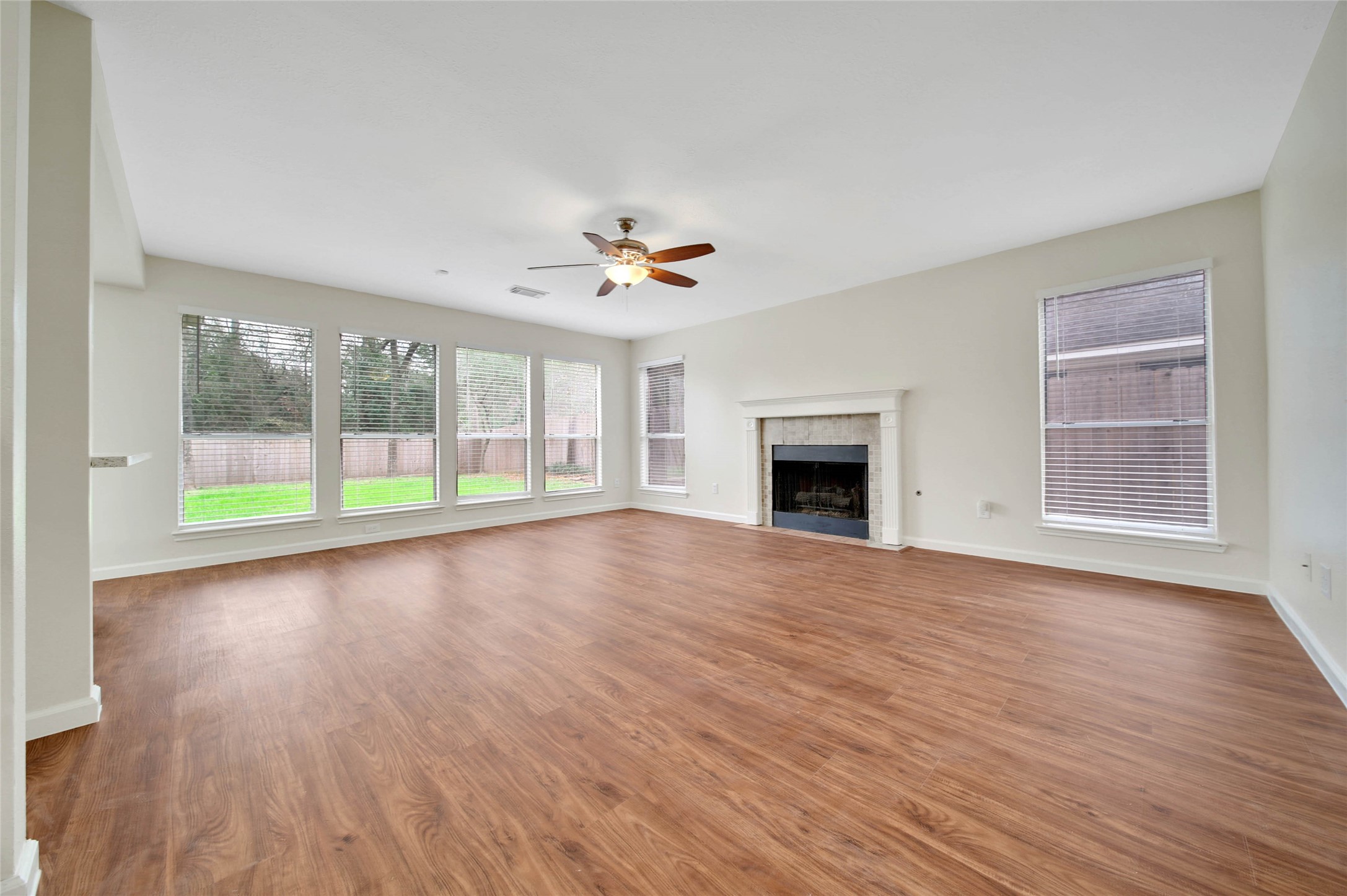 1427 Redwood Village Circle Spring, TX 77386 - Photo 17 of 43 an empty room with wooden floor and a fireplace