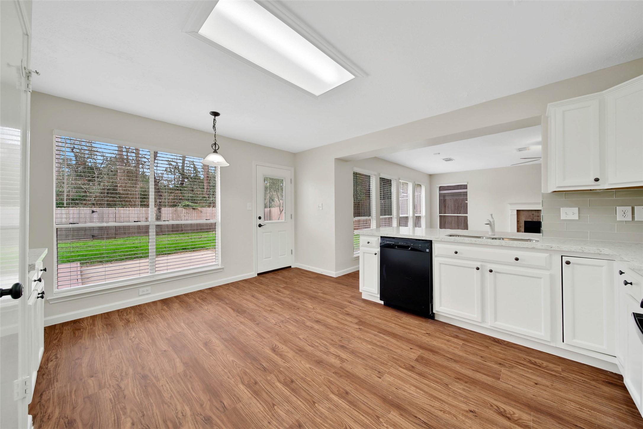 1427 Redwood Village Circle Spring, TX 77386 - Photo 23 of 43 a open kitchen with granite countertop a stove top oven a sink dishwasher and white cabinets with wooden floor