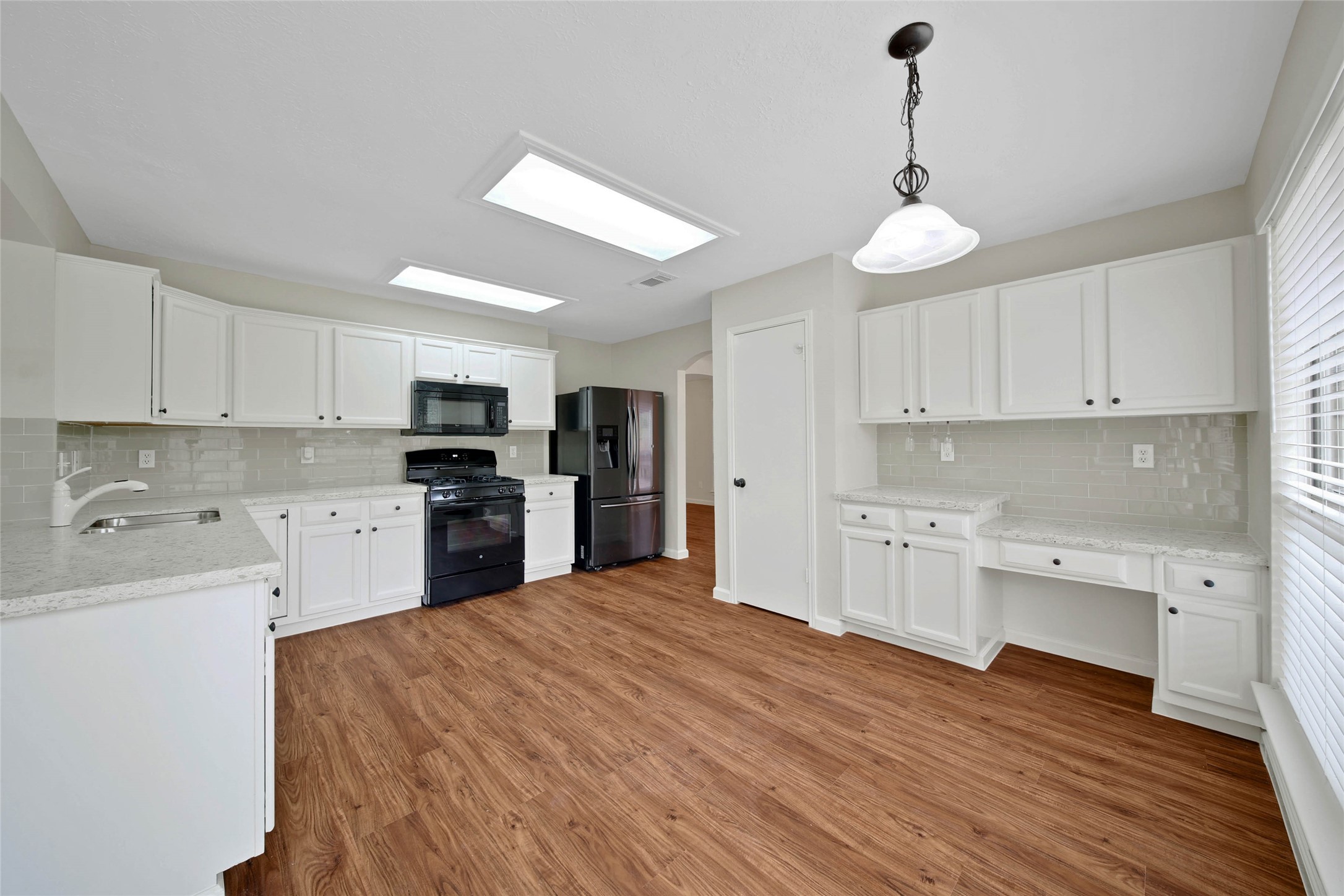 1427 Redwood Village Circle Spring, TX 77386 - Photo 25 of 43 a kitchen with cabinets wooden floor and stainless steel appliances