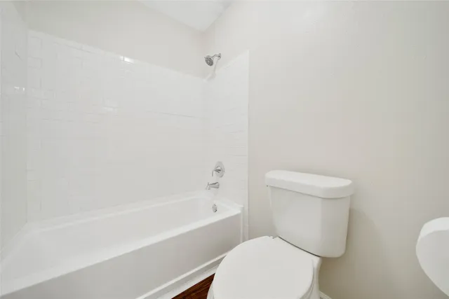 a bathroom with a granite countertop sink mirror and a toilet
