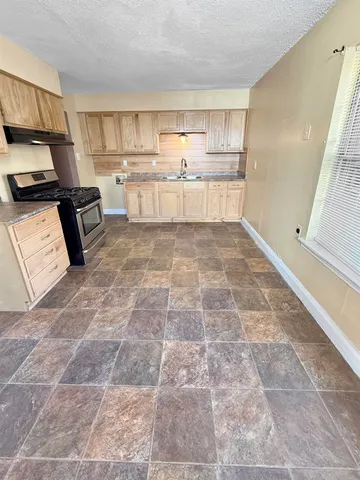a kitchen with a sink a stove and cabinets