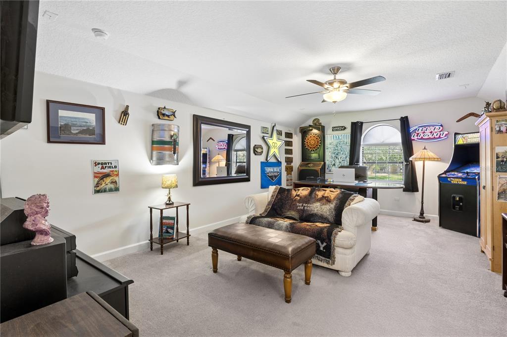 11325 Preston Cove Road Clermont, FL 34711 - Photo 34 of 58 a living room with furniture a chandelier and a flat screen tv