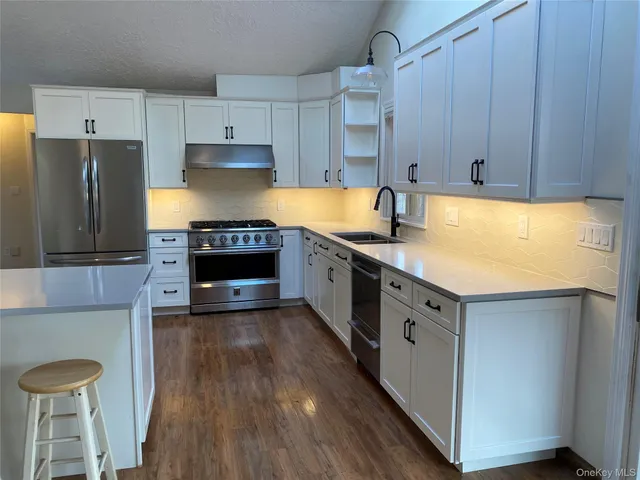 a kitchen with stainless steel appliances a stove a refrigerator and a oven