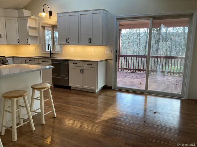 a kitchen with granite countertop wooden floors and a sink