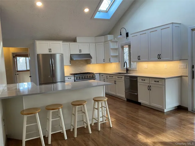 a kitchen with a table chairs refrigerator and microwave