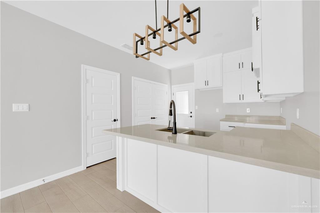 909 East 13th Street, Unit 4 San Juan, TX 78589 - Photo 5 of 14 a kitchen with stainless steel appliances granite countertop white cabinets and refrigerator