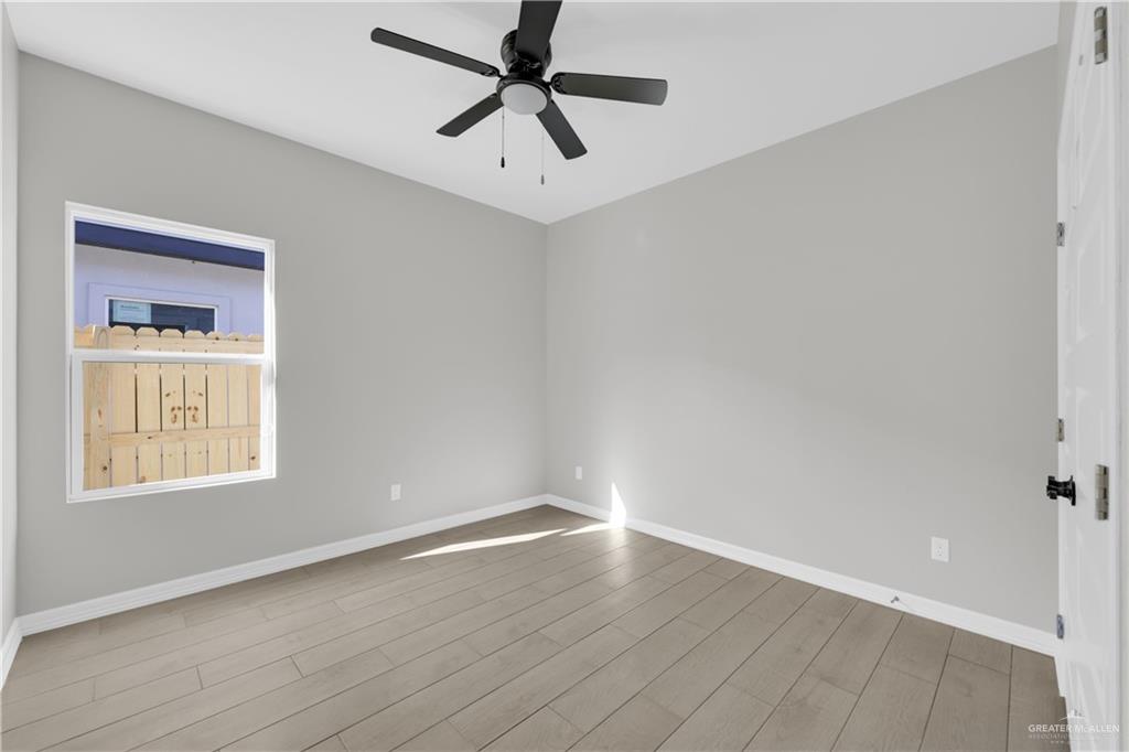 909 East 13th Street, Unit 4 San Juan, TX 78589 - Photo 9 of 14 wooden floor in an empty room with a window