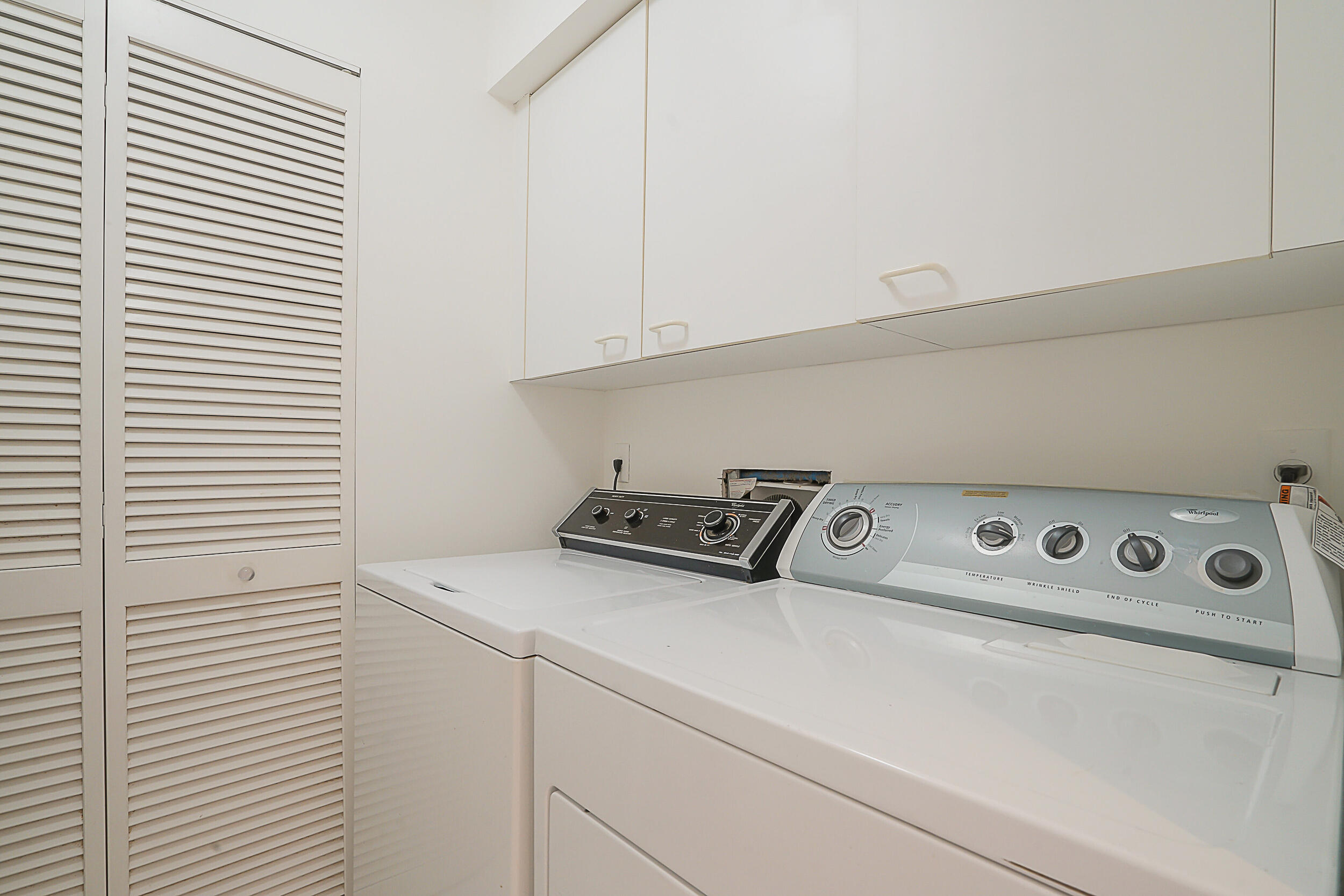 2703 Captains Way Jupiter, FL 33477 - Photo 28 of 57 a close up view of washer and dryer with kitchen countertops