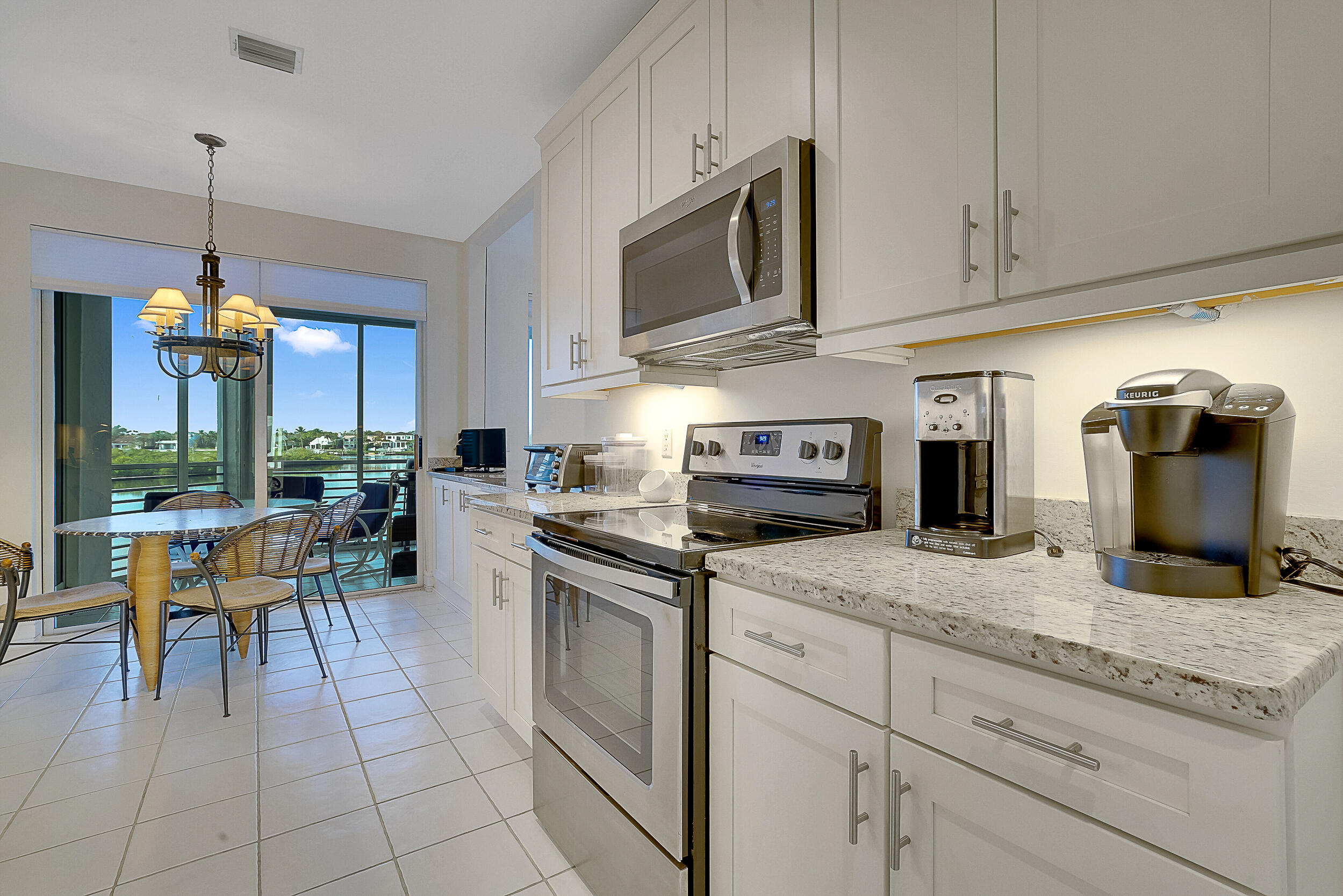2703 Captains Way Jupiter, FL 33477 - Photo 7 of 57 a kitchen with stainless steel appliances granite countertop a stove a sink and a microwave