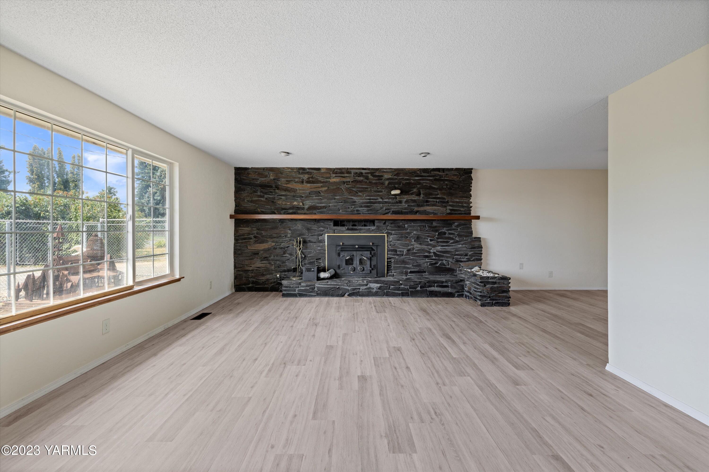 2901 Jones Road Wapato, WA 98951 - Photo 6 of 32 a view of empty room with wooden floor and fireplace