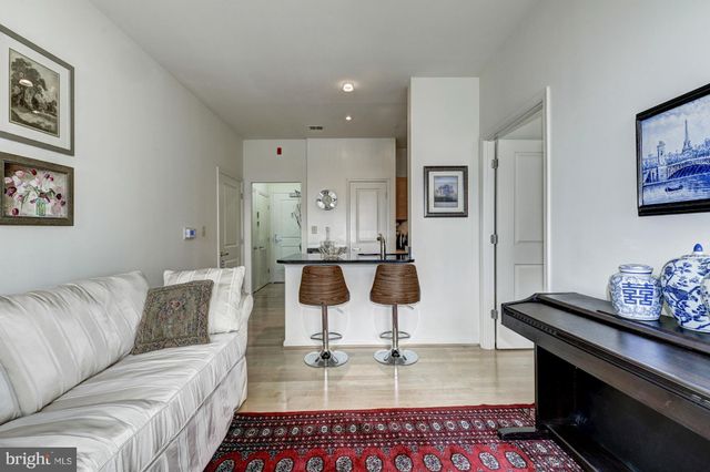 a living room with a couch and kitchen view