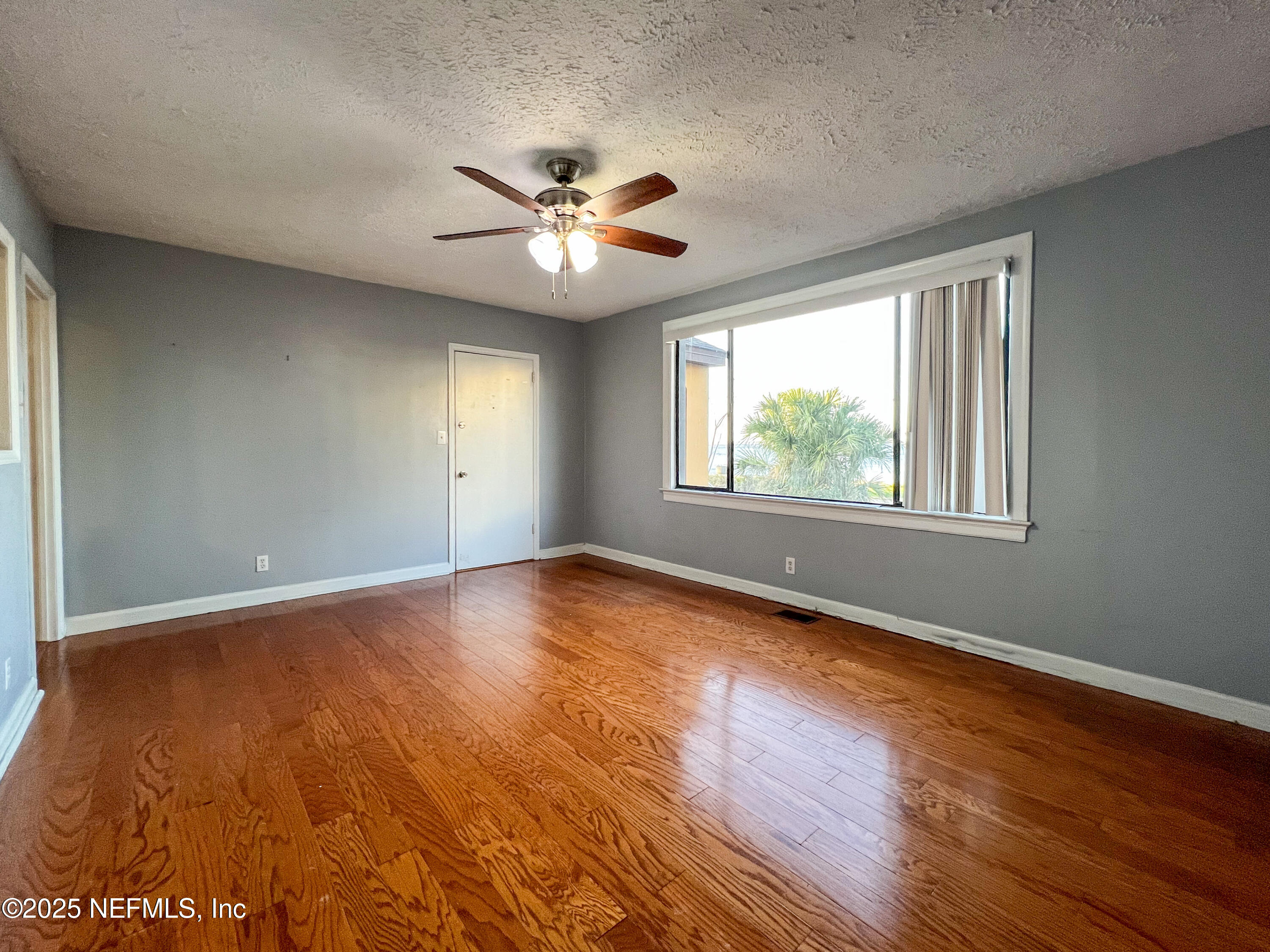 1733 River Road, Unit 1 Jacksonville, FL 32207 - Photo 4 of 16 a view of an empty room with chandelier fan and wooden floor