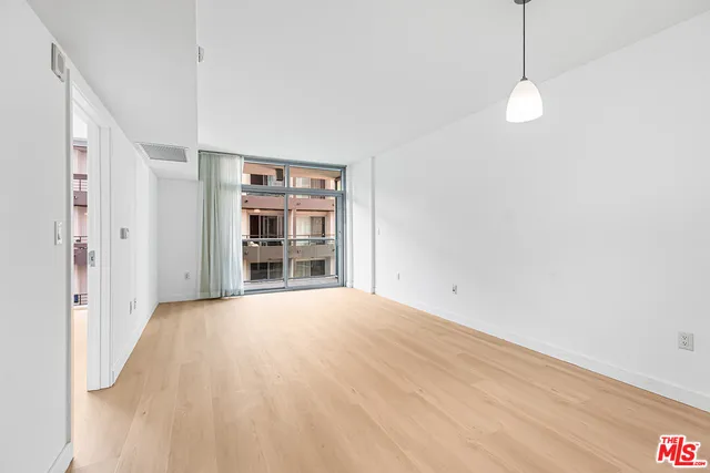 a view of empty room with wooden floor and window