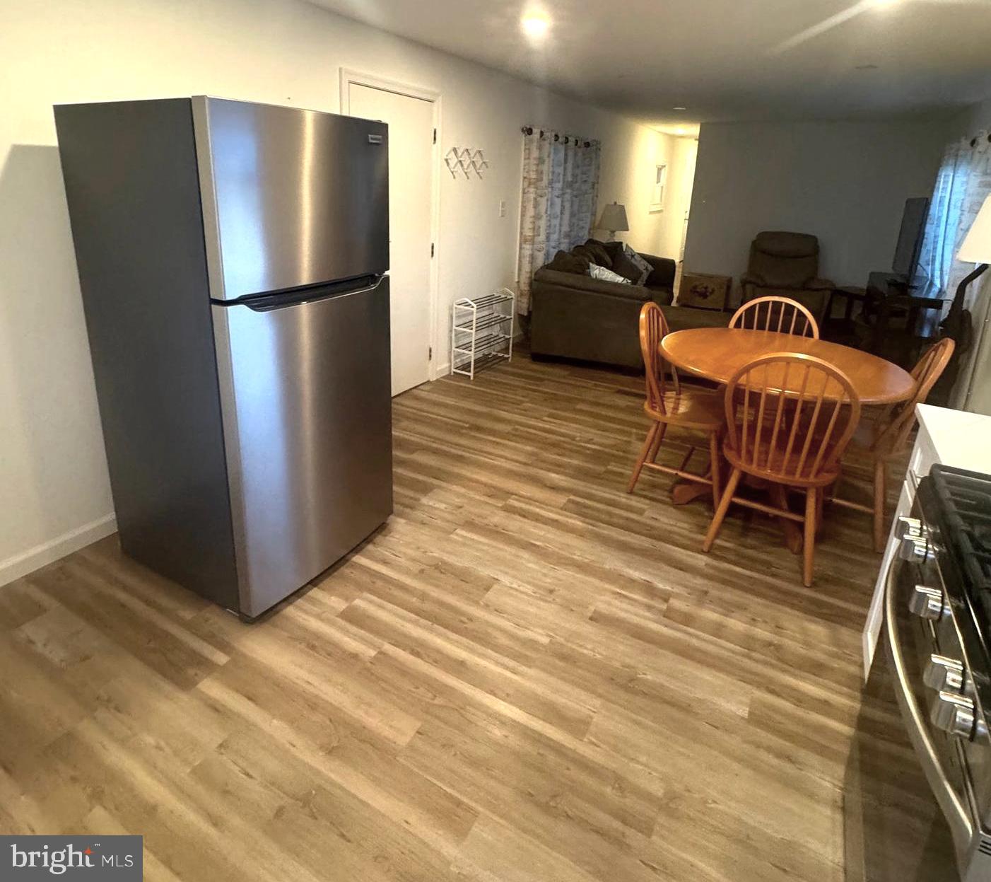 119 Clamshell Road Ocean City, MD 21842 - Photo 5 of 14 a refrigerator freezer sitting in a kitchen with stainless steel appliances wooden floor