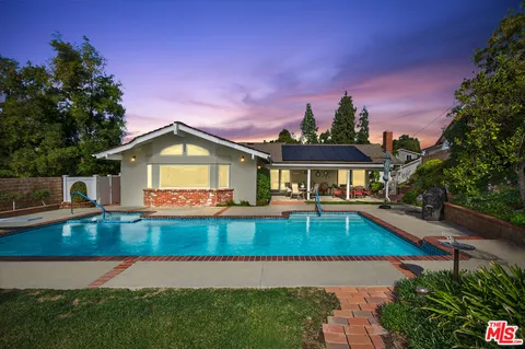 a swimming pool with outdoor seating and yard